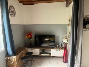 a living room with a tv and a table with chairs at les Renardeaux maison cosy idéal PRO CNPE PIPA et Familles in Ambutrix +5 photos