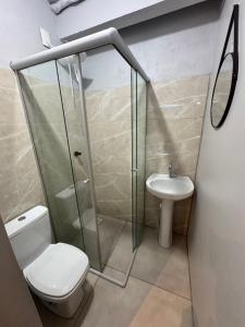 a bathroom with a shower and a toilet and a sink at Pousada Bonetti Quarto 11 in Santa Rosa