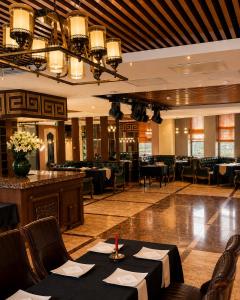 a dining room with tables and chairs in a restaurant at Kentavr Hotel in Ulaanbaatar