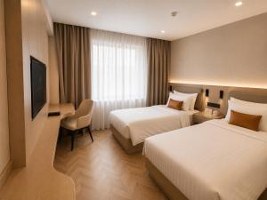 a hotel room with two beds and a television at Kentavr Hotel in Ulaanbaatar