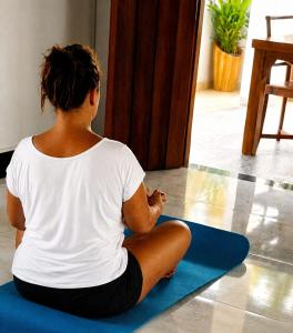 a woman sitting on the floor in a yoga pose at Lunara Sanctuary in Induruwa