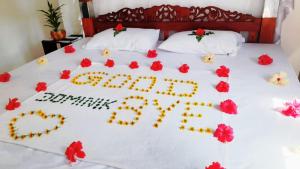 a birthday cake on a bed with flowers at Lunara Sanctuary in Induruwa