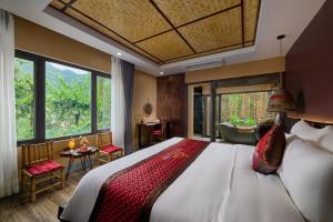 a bedroom with a large bed and a large window at Tam Coc Oasis Resort & Spa in Ninh Binh +68 photos