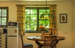 a kitchen with a table and a refrigerator and a window at The Bower at Wildside Sanctuary in Bilpin