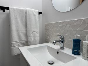 a bathroom with a sink and a mirror and towels at Ralf Residence in Bucharest