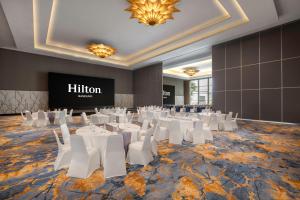 a banquet hall with white tables and white chairs at Hilton Bandung in Bandung +91 photos