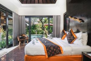 a bedroom with a large bed and a pool at Katala Suites and Villas in Sanur +82 photos