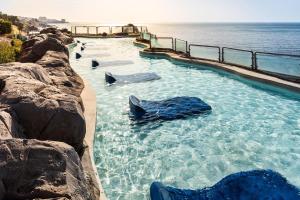 a swimming pool with rocks in the water at Holiday World Resort, Affiliated by Melia in Benalmádena