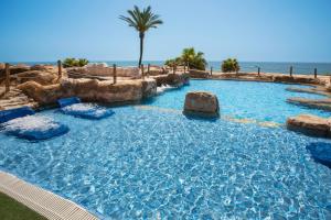 a large swimming pool in a resort with a palm tree at Holiday World Resort, Affiliated by Melia in Benalmádena