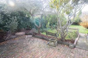a patio with two benches and a table and a tree at Picket Fence On Ligar in Ballarat