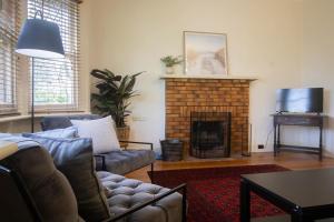 a living room with a couch and a fireplace at Picket Fence On Ligar in Ballarat