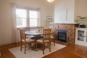 a kitchen with a table and chairs and a fireplace at Picket Fence On Ligar in Ballarat