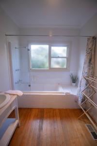 a white bathroom with a tub and a window at Picket Fence On Ligar in Ballarat +17 photos