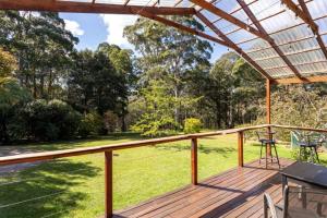 a large deck with a table and chairs on it at The Bower at Wildside Sanctuary in Bilpin