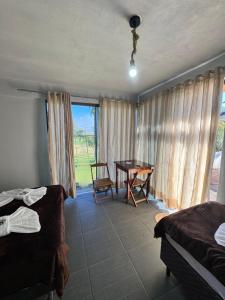 a bedroom with a desk and a table and a window at Pousada Bonetti Quarto 9 in Santa Rosa