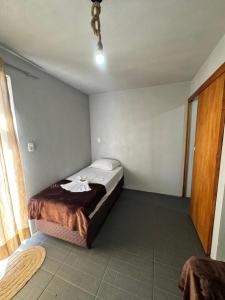 a bedroom with a bed in the corner of a room at Pousada Bonetti Quarto 9 in Santa Rosa
