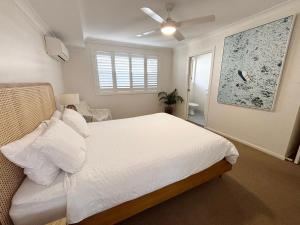 a bedroom with a white bed and a window at Baybreeze - Bring your own linen in South West Rocks