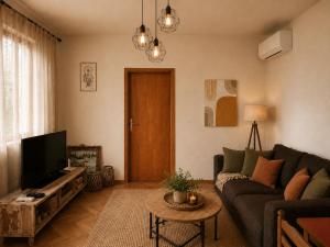 a living room with a couch and a tv at Green Little Cottage with Pool near Ostrog Monastery in Danilovgrad +16 photos