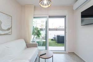 a living room with a white couch and a table at EriZen Jacuzzi suites in Keramoti