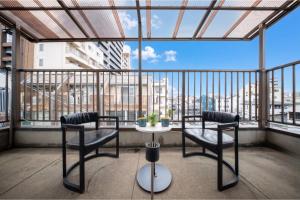a balcony with two chairs and a table in front of a window at en stay001 in Osaka