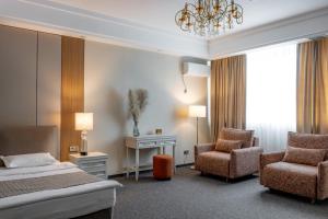 a bedroom with a bed and a chair and a desk at Mountain View Residence Hotel in Almaty +34 photos