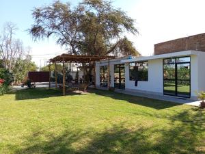 a house with a large yard with a grass field at Casa Rústica Diaz in Ica