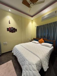 a bedroom with a large white bed in a room at Riddhi krrish Home stay in Mysore