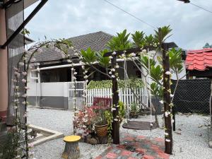 a garden with an arch with flowers and plants at DGarden Homestay in Kuala Terengganu +4 photos