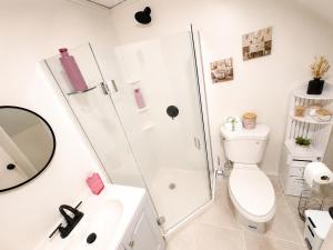 a bathroom with a shower and a toilet and a sink at Elegant Boutique Stay in Lilburn +19 photos