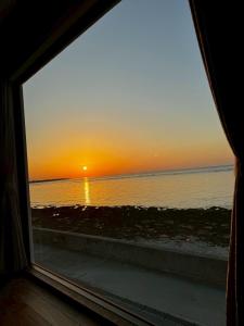 a view of a sunset from a window at HERO VILLA ocean suite in Ishigaki Island