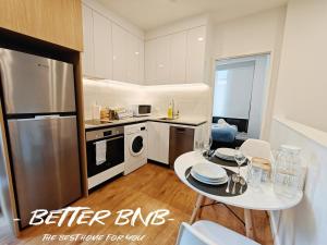 a small kitchen with a table and a refrigerator at The Elegant Corner in Wellington