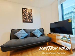 a living room with a couch and a flat screen tv at The Elegant Corner in Wellington