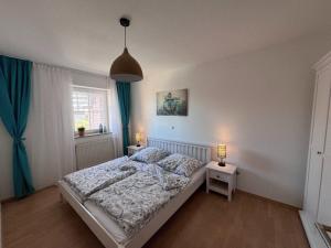 a bedroom with a bed and two lamps on tables at Lachmoewe in Orth
