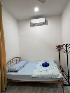 a bedroom with a bed with a blue pillow at DGarden Homestay in Kuala Terengganu