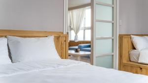 a bedroom with a white bed and a mirror at Geoje Memory Kidspoolvilla in Geoje