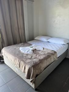 a bed with two towels on top of it at Pousada Bonetti Quarto 8 in Santa Rosa