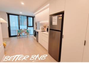 a kitchen with a stainless steel refrigerator and a table at Bloom Central – Pool & Gym in Wellington