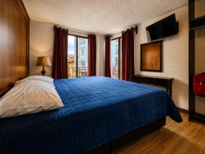 a bedroom with a blue bed and a window at Hotel Avenida in Zacatlán