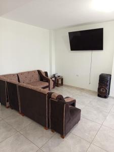 a living room with a couch and a flat screen tv at Casa Rústica Diaz in Ica