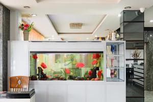 a large aquarium in a room with red flowers at Golden Gate Hotel in Bagam