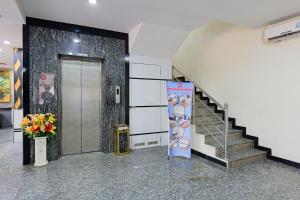 a lobby with a staircase and a door with a vase of flowers at Golden Gate Hotel in Bagam
