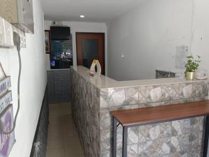a restaurant with a counter and a table in a room at VKB Ferringhi Styles Penang formerly Grand Star Hotel in Batu Ferringhi