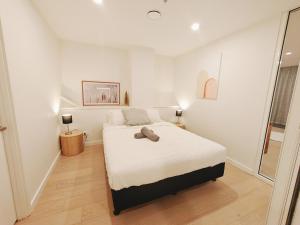 a white bedroom with a bed and a window at The Urban Nest 613 in Wellington