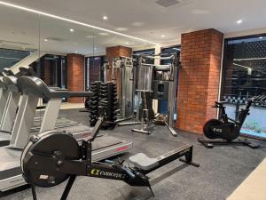 a gym with treadmills and machines in a room at The Urban Nest 613 in Wellington