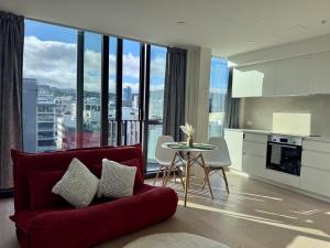 a living room with a red couch and a table at The Urban Nest 613 in Wellington