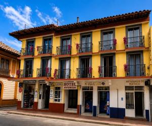 a yellow building with windows and balconies on a street at Hotel Avenida in Zacatlán