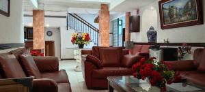 a living room with brown leather couches and a table at Hotel Avenida in Zacatlán +35 photos