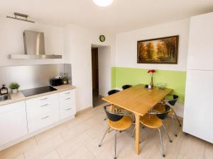 a kitchen with a wooden table and chairs at Ferienwohnung Gartenblick in Laupheim