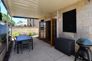 a patio with a table and a flat screen tv at Radford Retreat in Safety Bay
