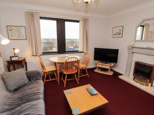 a living room with a couch and a table and a television at Harbour Side in Maryport
